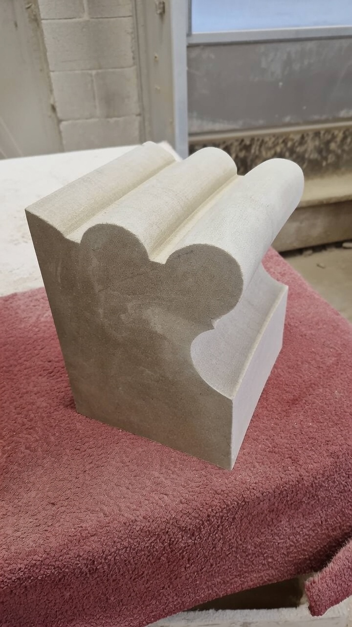 Hand-carved limestone kneeler with a cusped profile and rolled mouldings, worked in the masonry workshop