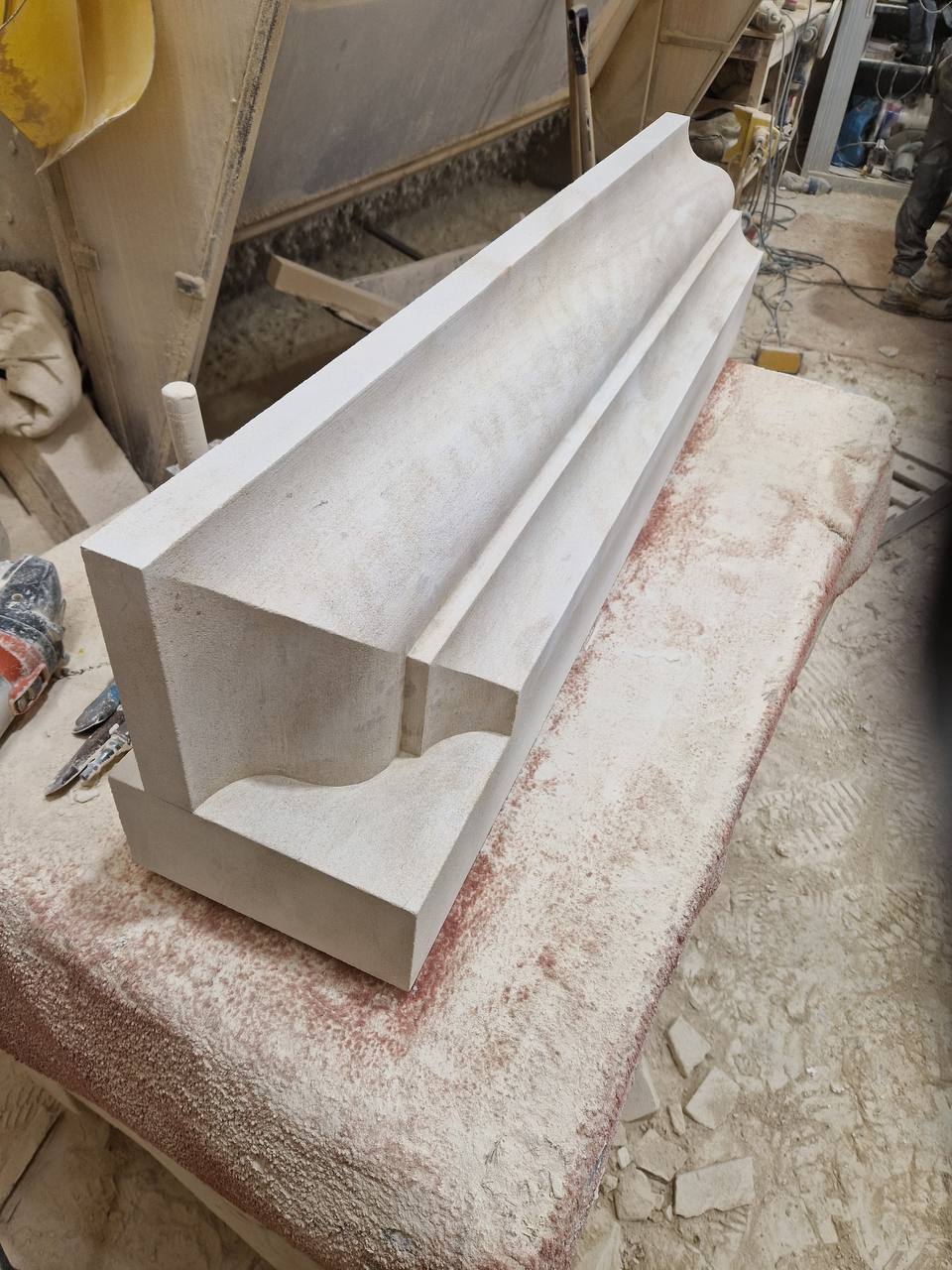 Long moulded limestone string course with a cavetto and roll profile, hand-worked and finished on the banker in the masonry workshop
